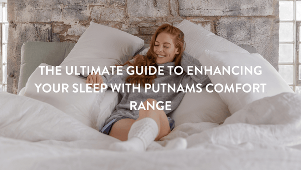 Person propped up in bed on Putnams pillows wearing a grey polo neck jumper