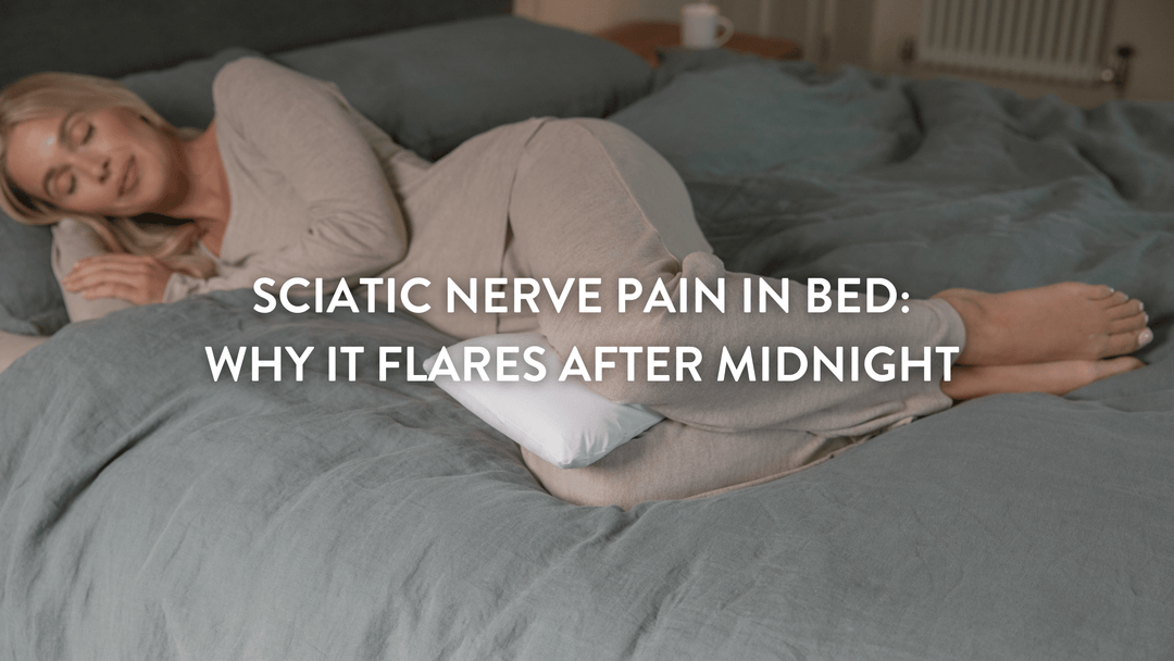 Person sleeping on their side in a large double bed witha Putnams butterfly pillow between their knees 