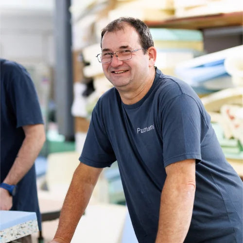 UK manufacturing employee cutting foam for pillows and sofa cushions